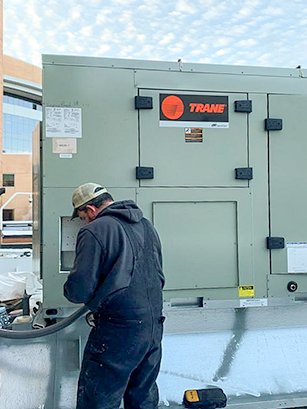 Sensible Solutions employee servicing a commercial HVAC unit